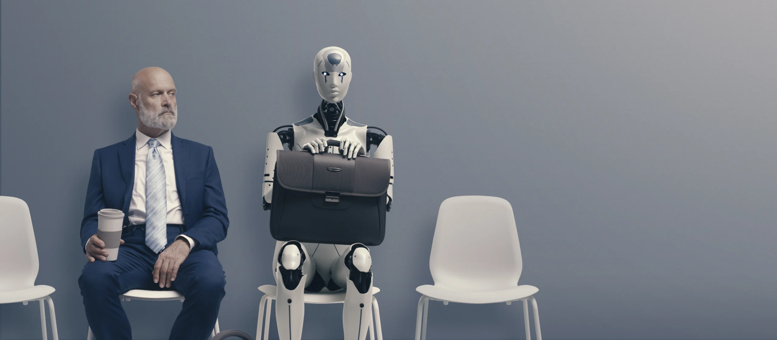 man sitting next to a robot